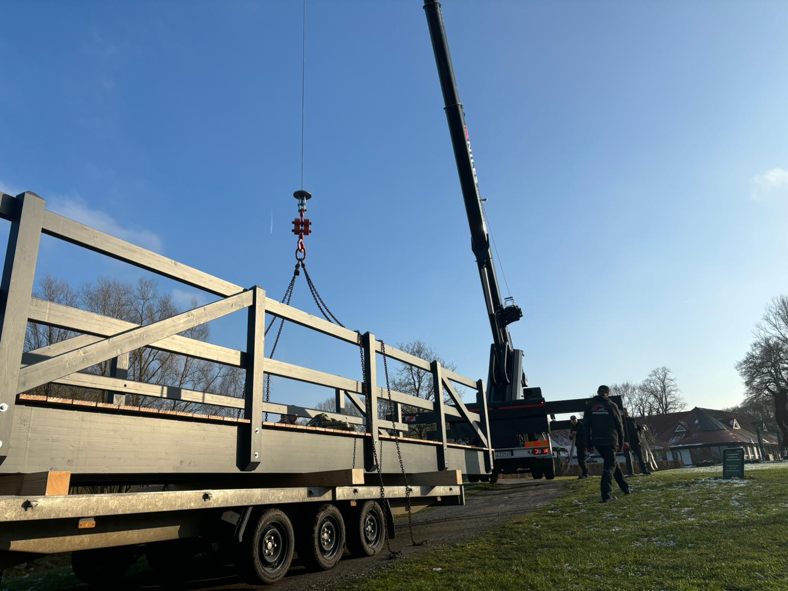 Holzbrücke wird per Kran von Anhänger gehoben – Kranverleih Emmerich